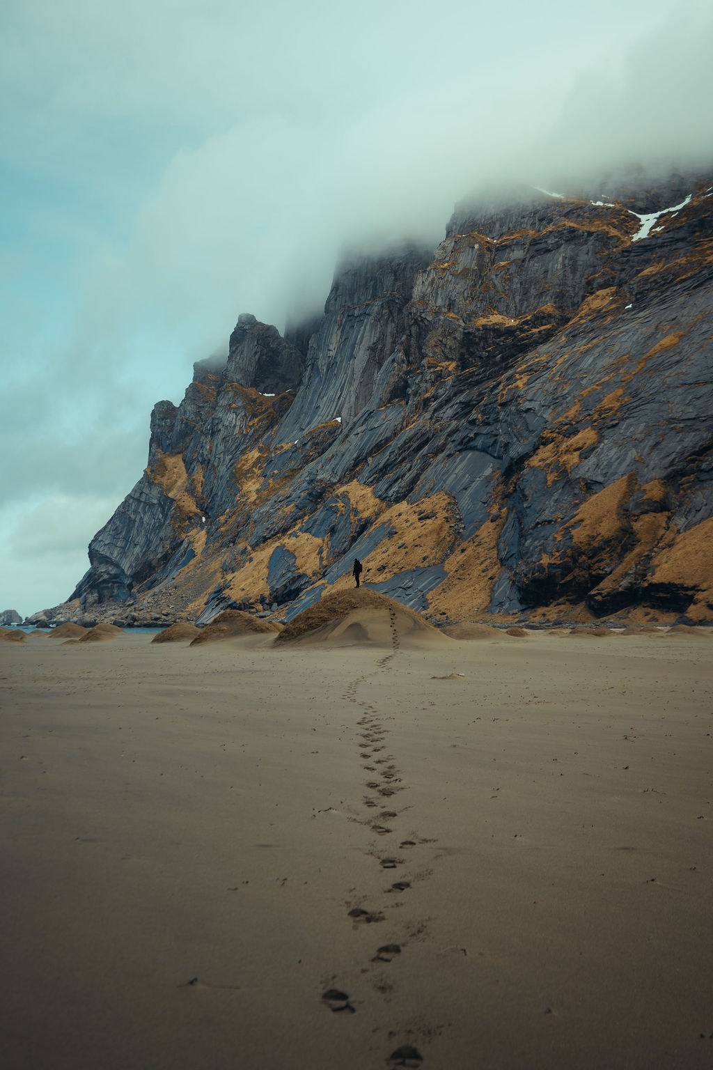 Fotspor på en stille strand i Lofoten
